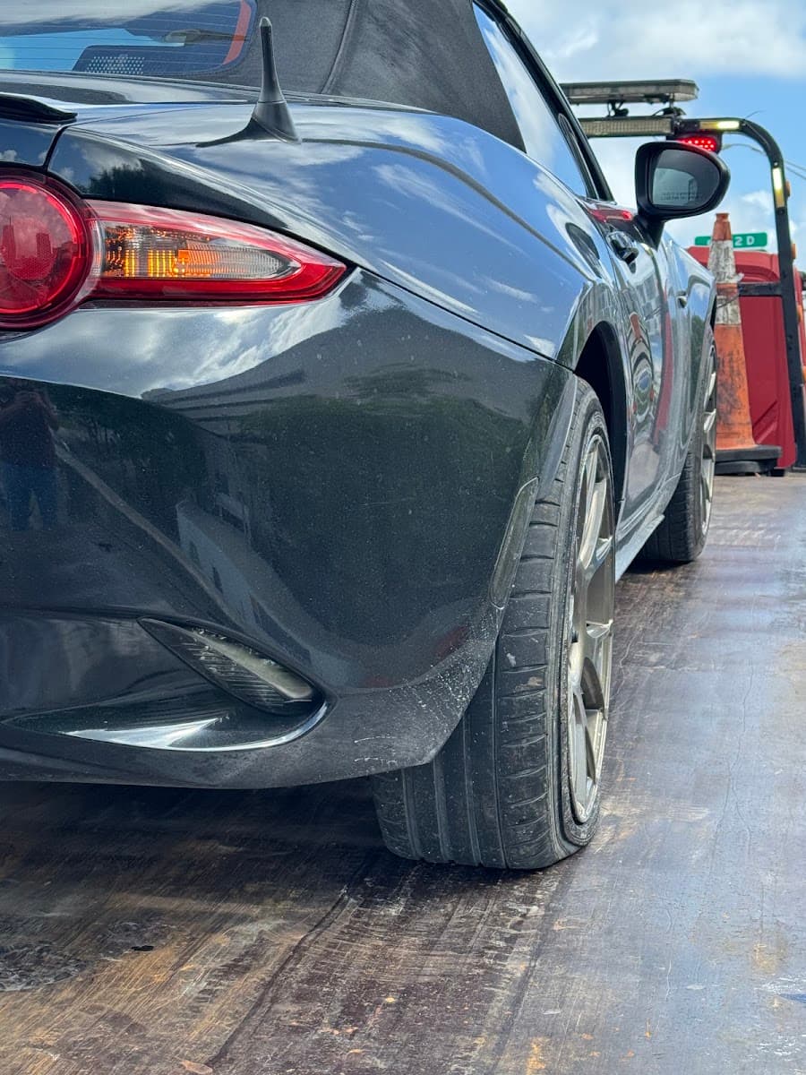 A car up on a jack stand getting new tires at Quick Tire