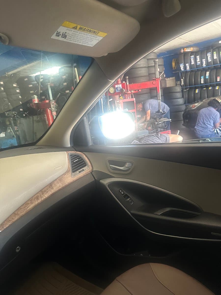Mechanic working inside a car at the Quick Tire garage bay
